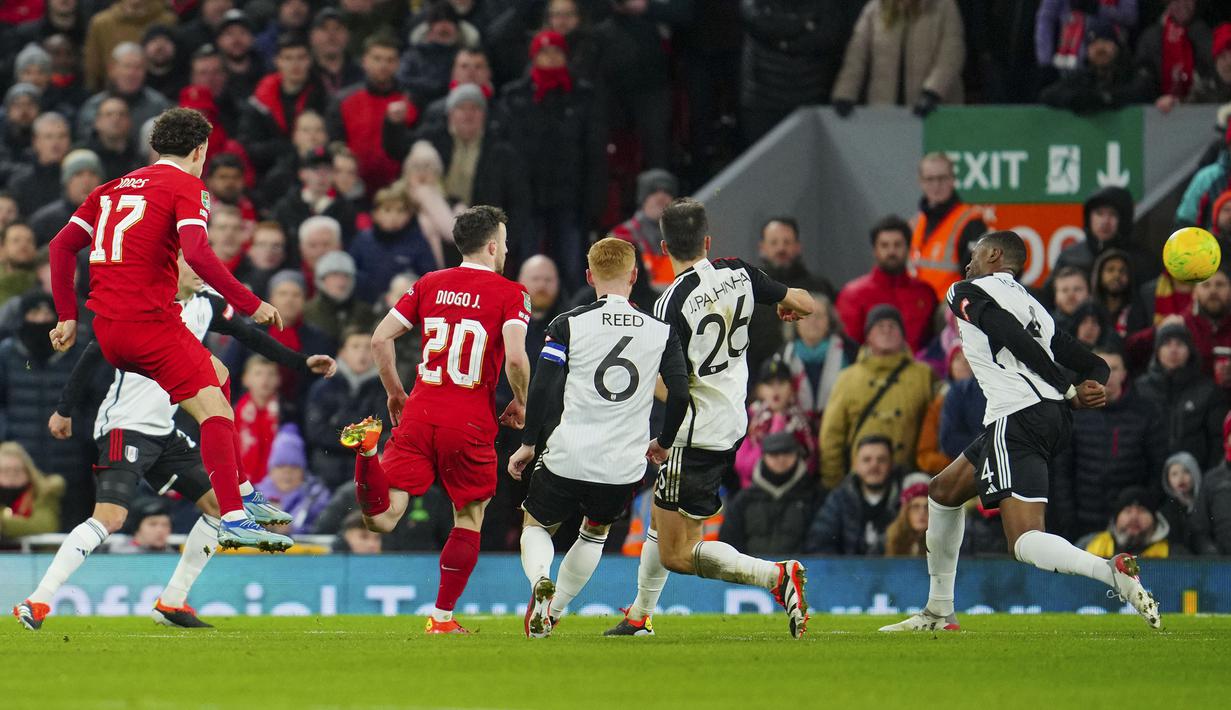 Gelandang Liverpool, Curtis Jones (kiri) melepaskan tendangan yang menghasilkan gol pertama ke gawang Fulham pada laga leg pertama babak semifinal Carabao Cup 2023/2024 di Anfield Stadium, Liverpool, Kamis (11/1/2024) dini hari WIB. (AP Photo/Jon Super)