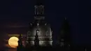 Bulan purnama muncul pada malam hari di belakang Frauenkirche di Dresden, Jerman, Rabu (13/7/2022). Bulan Purnama dikenal sebagai Buck Moon dan juga Supermoon. Di kondisi ini Bulan akan terlihat tampak lebih besar dan terang sehingga terasa sangat dekat dari Bumi. (Robert Michael/dpa via AP)