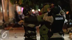Petugas polisi dari Tim Penjinak Bom Gegana bersiap sebelum  mengevakuasi benda diduga bom di kawasan pantai Lagoon, Ancol, Jakarta Utara, Sabtu (31/12) malam. (Liputan6.com/Gempur M. Surya)