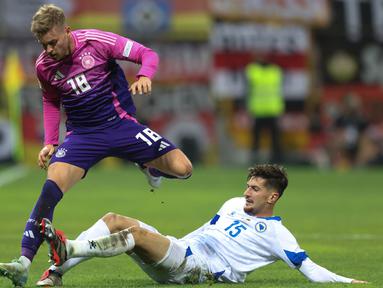 Pemain Bosnia-Herzegovina, Armin Gigovic (bawah) mencoba menahan laju Maximilian Mittelstadt (Jerman) matchday 3 Grup C UEFA Nations League A 2024/2025 di Bilino Polje Stadium, pada Jumat 11 Oktober 2024 atau Sabtu 12 Oktober 2024 dini hari WIB. (AP Photo/Armin Durgut)