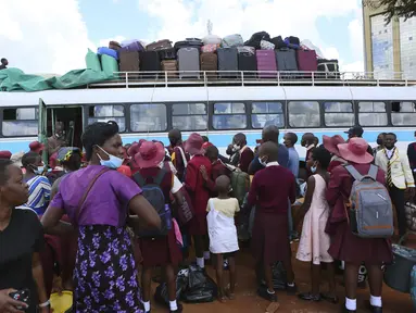 Anak-anak sekolah menunggu untuk naik bus menuju sekolah di Harare, Minggu (6/2/2022). Sekolah-sekolah di Zimbabwe dibuka kembali pada 7 Februari setelah penundaan selama berminggu-minggu dalam mengizinkan siswa kembali menyusul meningkatnya infeksi COVID-19. (AP Photo/Tsvangirayi Mukwazhi)