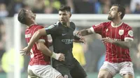 Aksi pemain Manchester City, Sergio Aguero berebut bola dengan dua pemain Bristol City pada semifinal Piala Liga Inggris di Ashton Gate stadium, Bristol,(23/1/2018). Manchester City menang 3-2. (Nick Potts/PA via AP)