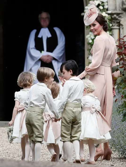Kate Middleton mengatur pengiring pengantin masuk ke lokasi pernikahan Pippa Middleton dan  James Matthews, di Gereja St. Mark, Sabtu (20/5). Ada tujuh pengiring pengantin, termasuk Pangeran George dan Putri Charlotte. (AP Photo/Kirsty Wigglesworth, Pool)
