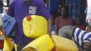 Seorang pria membawa wadah plastik kosong di pasar Kaporo di Conakry, Guinea, Senin (13/9/2021). Pasukan elit militer Guinea melakukan kudeta dan menangkap Presiden Alpha Conde pada Minggu, 5 September lalu. (AP Photo/ Sunday Alamba)
