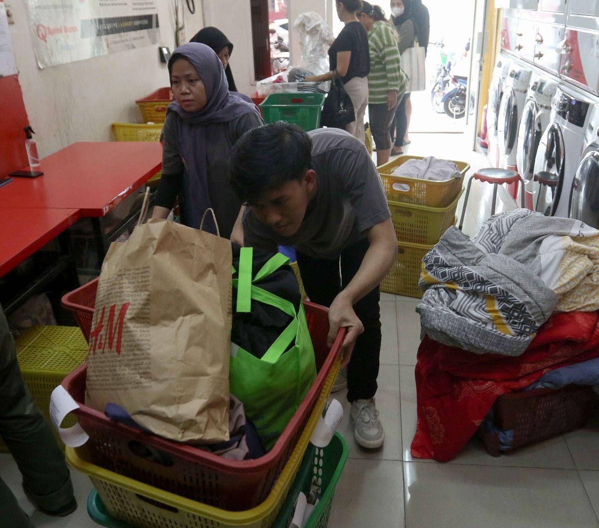 Kesibukan pekerja di tengah tingginya permintaan pada sebuah penyedia jasa laundry di kawasan Ampera Raya, Jakarta, Rabu (17/4/2024).&nbsp;Permintaan layanan penatu pakaian atau laundry meningkat setelah libur panjang Lebaran. Liputan6.com/Herman Zakharia