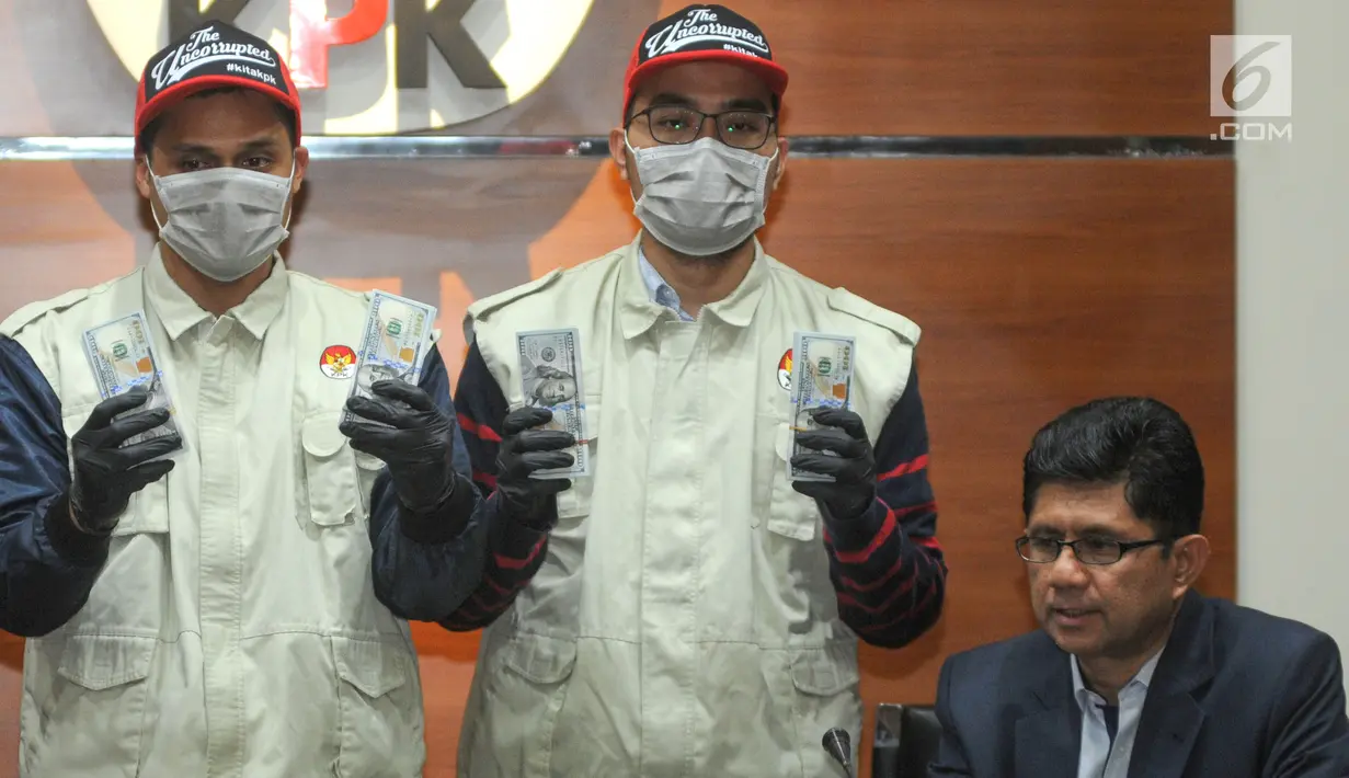 Petugas disaksikan Wakil Ketua KPK Laode M Syarif menunjukkan barang bukti hasil OTT Bupati Muara Enim uang 35.000 dollar AS di Gedung KPK, Jakarta, Selasa (3/9/2019). Uang tersebut terkait suap 16 proyek peningkatan pembangunan jalan di Muara Enim. (merdeka.com/Dwi Narwoko)
