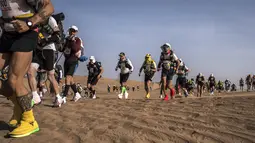 Sejumlah peserta bersaing dalam kejuaraan Marathon des Sables ke-33 tahap kedua di Gurun Sahara, selatan Maroko, Senin (9/4). Marathon ini menempuh perjalanan 6 hari dengan jarak tempuh sejauh 250 kilometer. (JEAN-PHILIPPE KSIAZEK/AFP)