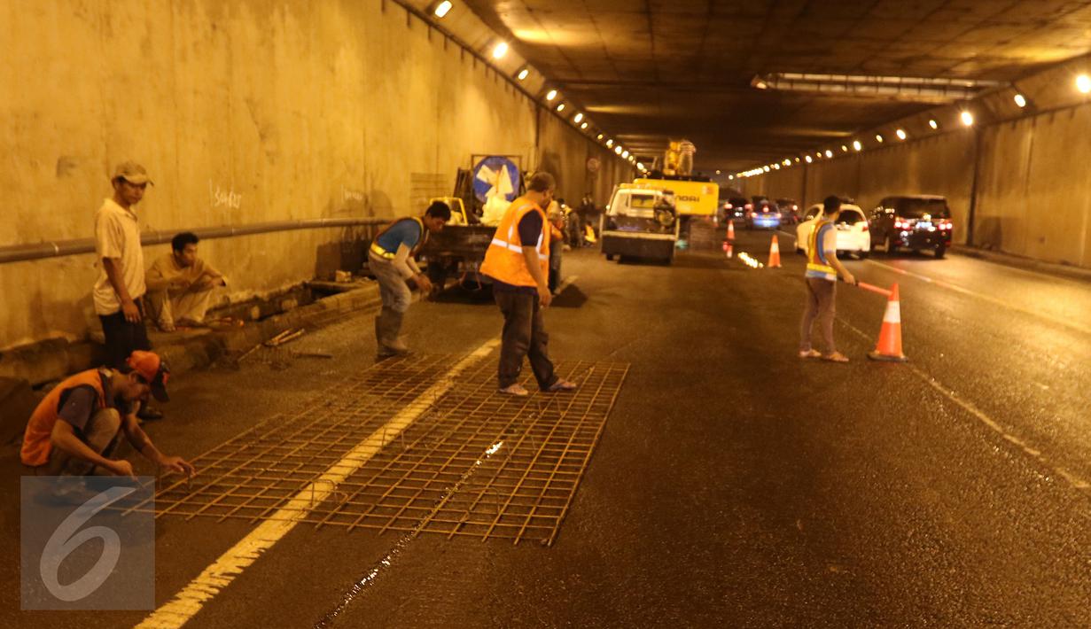 Sejumlah pekerja bersiap memperbaiki jalan yang rusak berlubang di ruas Tol JORR tepatnya di terowongan Pasar Rebo, Jakarta, Senin (29/2) malam. Kondisi jalan yang rusak itu menyebabkan kemacetan panjang. (Liputan6.com/Herman Zakharia)