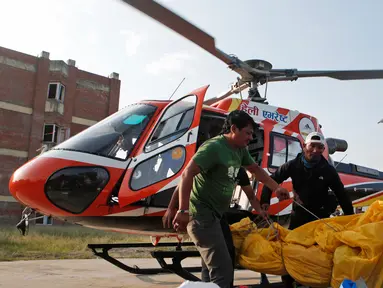 Jasad pendaki India yang tewas di  Everest diturunkan dari helikopter setibanya di ibu kota Nepal, Minggu (28/5). Jasad Ravi Kumar diterbangkan ke Kathmandu bersama dengan jasad dua orang lainnya yang meninggal tahun lalu. (AP Photo/Niranjan Shrestha)