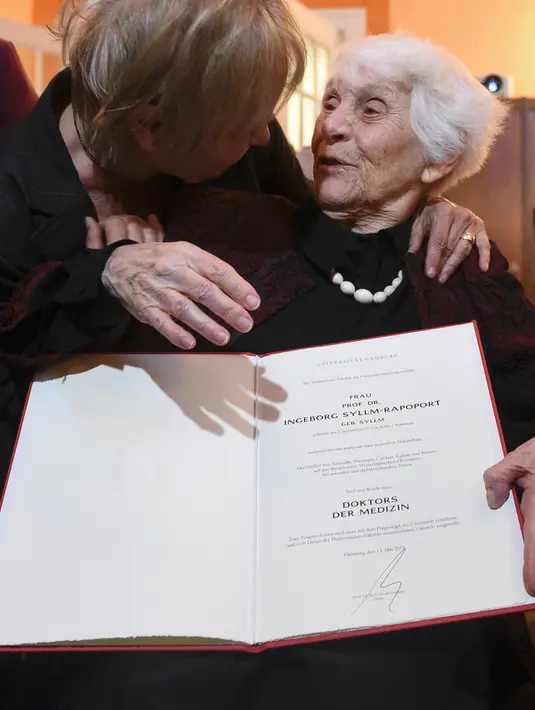 Seorang wanita mengucapkan selamat kepada Ingeborg Rapoport (102 tahun) saat ia berpose menunjukkan sertifikat doktornya yang baru dia terima, di rumah sakit UKE di Hamburg, Jerman, Selasa (9/6/2015). (REUTERS/Fabian Bimmer)