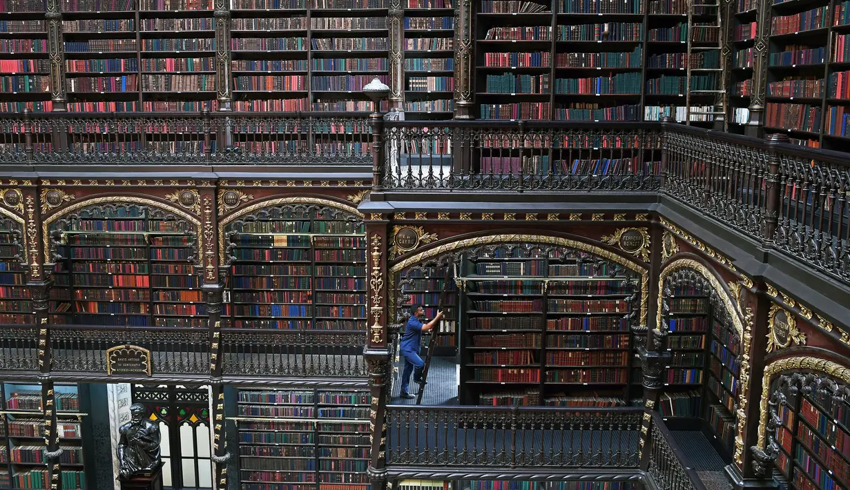 Pekerja menaiki tangga di Royal Portuguese Cabinet of Reading di Rio de Janeiro, Brasil, 19 November 2018. Royal Portuguese Cabinet of Reading dibuka untuk umum sejak 1900. (Carl De Souza/AFP)