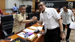 Menteri Hukum dan Hak Asasi Manusia (Menkumham) Yasonna Laoly bersalaman dengan Wakil Ketua Komisi III F-PDIP, Trimedya Pandjaitan saat akan dimulainya rapat kerja di kompleks Parlemen, Jakarta,  Rabu (6/3). (Liputan6.com/Johan Tallo)