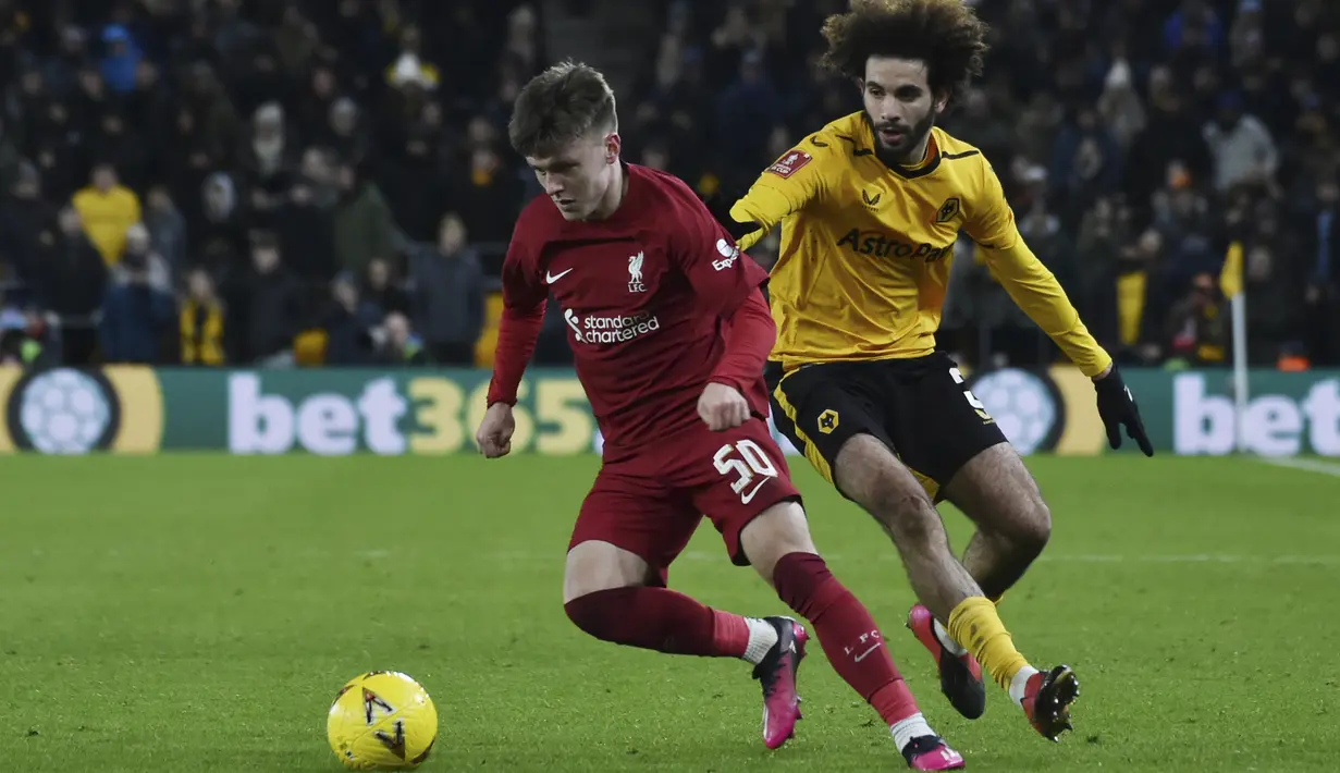 Bek  Wolverhampton Wanderers Rayan Ait-Nouri berebut bola dengan penyerang Liverpool Ben Doak dalam partai replay putaran ketiga Piala FA 2022/2023 di Molineux Stadium, Rabu dini hari WIB (18/1/2023). Liverpool cukup menang tipis 1-0 atas Wolverhampton. (AP Photo/Rui Vieira)