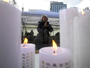Seorang wanita berdoa untuk keberhasilan anak dan kerabatnya dalam mengikuti tes kemampuan Skolastik College tahunan di Seoul (23/11). Mereka mendoakan anaknya agar dapat lulus ujian masuk perguruan tinggi. (AFP Photo/Jung Yeon-Je)