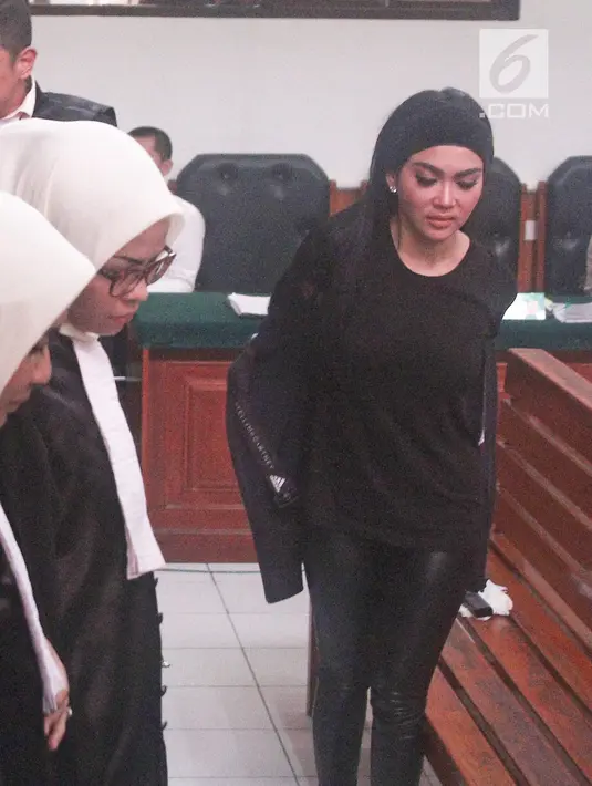 Penyanyi Syahrini membuka jaket yang dikenakannya saat menjadi saksi persidangan kasus First Travel di Pengadilan Negeri Depok, Senin (2/4). Merasa kegerahan, Syahrini meminta izin membuka jaketnya lalu kipas-kipas. (Liputan6.com/Herman Zakharia)