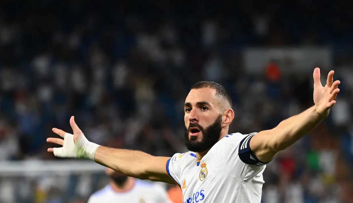 Pemain Real Madrid Karim Benzema melakukan selebrasi usai mencetak gol ke gawang Celta Vigo pada pertandingan Liga Spanyol di Stadion Santiago Bernabeu, Madrid, Spanyol, 12 September 2021. Karim Benzema mencetak hattrick saat Real Madrid mengalahkan Celta Vigo 5-2. (GABRIEL BOUYS/AFP)