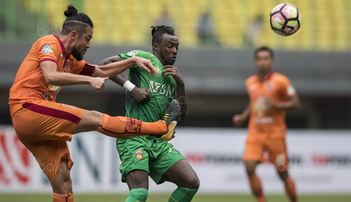 Bek Borneo FC, Yamashita Kunihiro, membuang bola dari kejaran striker Bhayangkara FC, Guy Junior, pada laga Liga 1 Indonesia di Stadion Patriot, Bekasi, Rabu (20/9/2017). Bhayangkara menang 2-1 atas Borneo. (Bola.com/Vitalis Yogi Trisna)