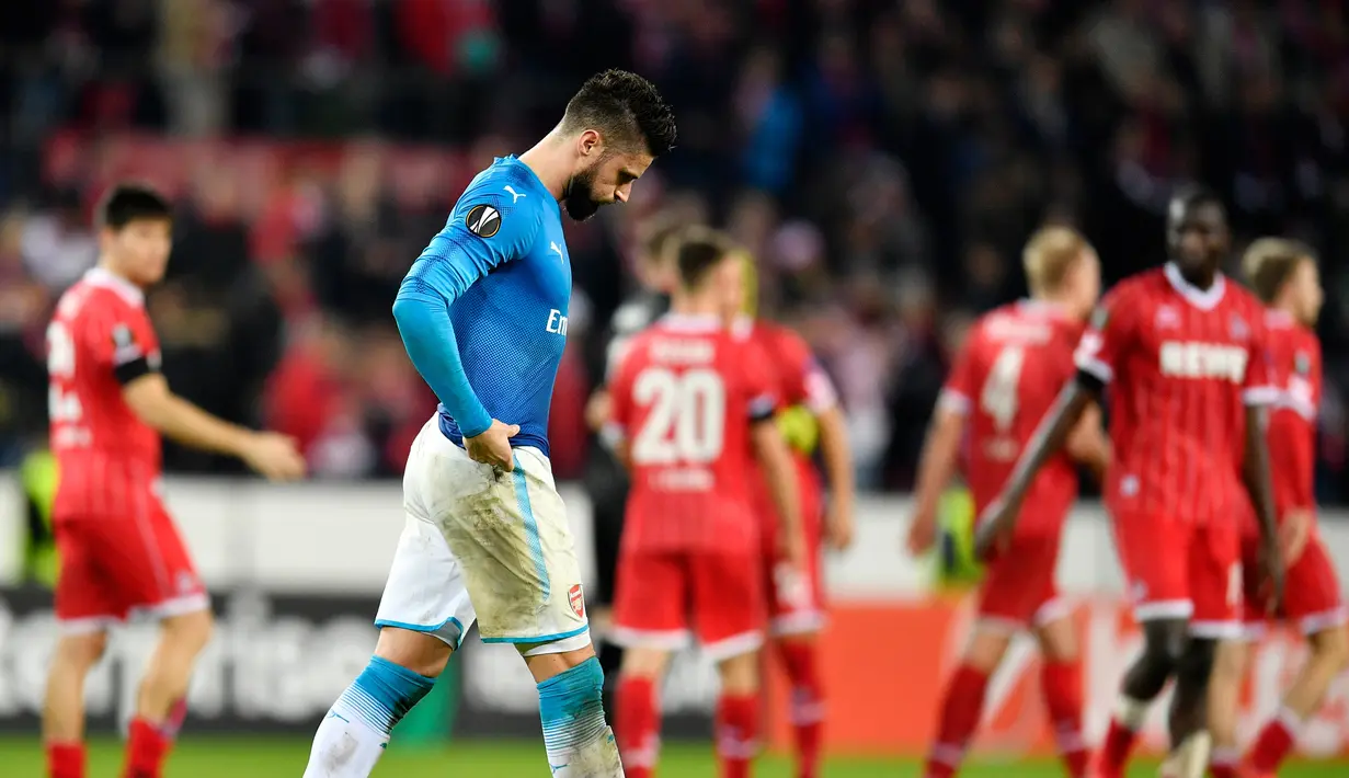 Pemain Arsenal, Olivier Giroud tertunduk lesu meninggalkan lapangan usai matchday kelima Liga Europa Grup H kontra FC Koln di RheinEnergieStadion, Jumat (24/11). Meski kalah 0-1 dari FC Koln, Arsenal tetap lolos sebagai juara Grup H. (AP/Martin Meissner)