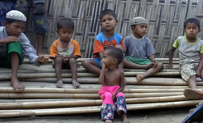 Anak-anak Rohingya tengah duduk di atas tumpukan pohon bambu di kamp pengungsi Dar Paing, di utara Sittwe, Rakhine (AP Photo)