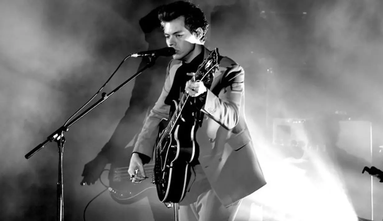 Di setiap penampilannya di atas panggung, Harry selalu menyapa para penggemarnya yang hadir saat itu. Dan di acara itu, Harry mendekati ujung panggung dan merapat ke arah penonton yang berdiri.  (AFP/Kevin Winter)