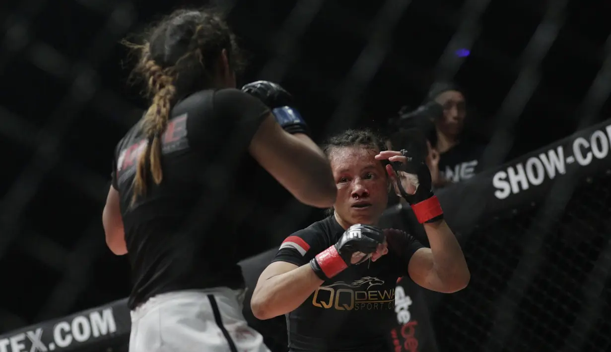 Petarung Indonesia, Priscilla Lumban Gaol, bersiap memukul petarung India, Puja Tomar, saat bertarung pada laga ONE Championship di Istora Senayan, Jakarta, Sabtu (19/1). Priscilla kalah dari Puja. (Bola.com/M. Iqbal Ichsan)