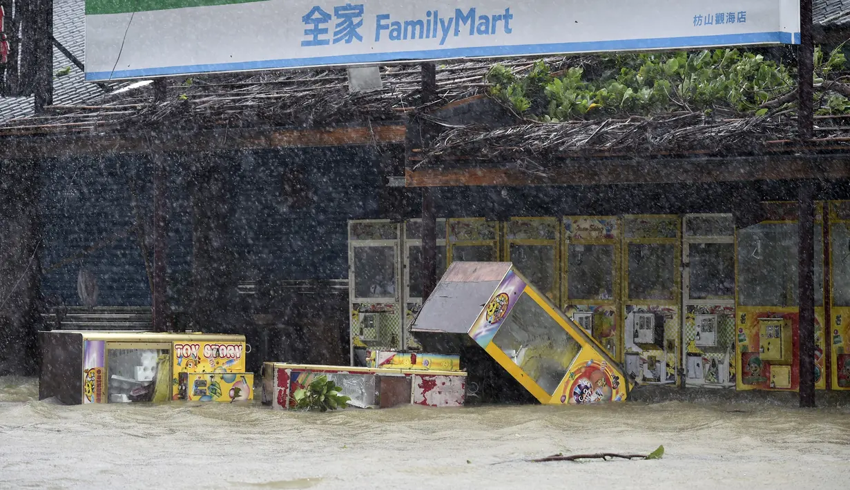 Sejumlah mesin penjual di depan sebuah toko tergenang banjir yang dipicu topan Meranti disertai hujan dan angin kencang di Pingtung, Taiwan selatan, Rabu (14/9). Sedikitnya 1.500 warga setempat dievakuasi dari rumah masing-masing. (AFP PHOTO/Sam YEH)