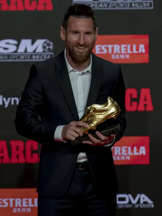 Pemain Barcelona FC, Lionel Messi tersenyum saat berpose dengan trofi Sepatu Emas keenamnya di Antiga Fabrica Estrella Damm, Barcelona, Spanyol (16/10/2019). Sebelumnya, Messi pernah merebutnya pada 2010, 2012 dan 2013. (AP Photo/Joan Monfort)