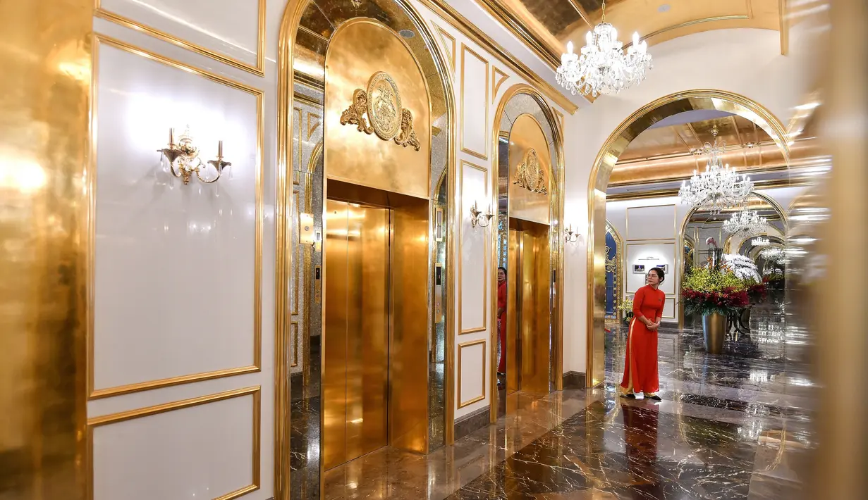 Seorang pegawai berdiri di dekat lift hotel Dolce Hanoi Golden Lake yang baru saja diresmikan di Hanoi, Vietnam pada Kamis (2/7/2020). Hotel tersebut merupakan hotel berlapiskan emas 24 karat pertama di dunia. (Manan VATSYAYANA / AFP)