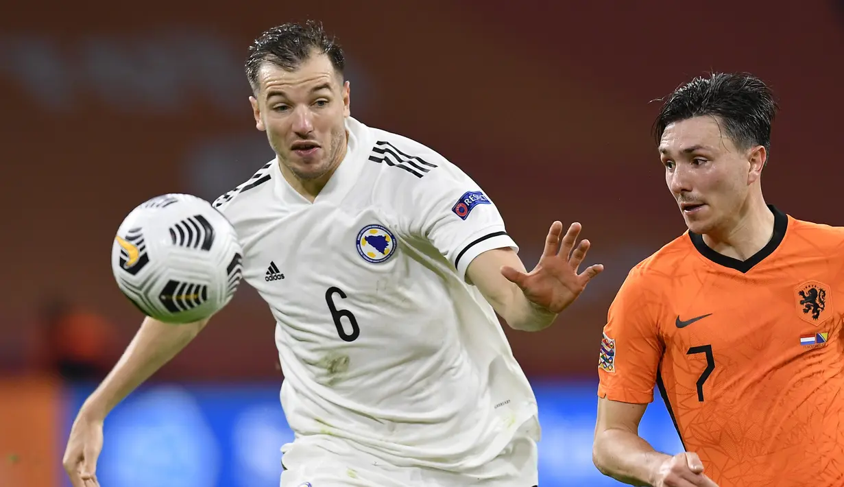 Pemain Bosnia & Herzegovina, Sinisa Sanicanin berebut bola dengan pemain Belanda, Steven Berghuis pada pertandingan UEFA Nations League di Johan Cruyff ArenA di Amsterdam, Belanda, Minggu (15/11/2020). Belanda menang atas Bosnia & Herzegovina 3-1. (John Thys/Pool via AP)