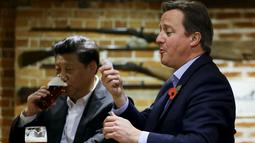 PM Inggris David Cameron (kanan) memegang beberapa lembar untuk membayar minuman yang ia pesan di sebuah bar, Princess Risborough, Inggris, Kamis (22/10/2015). Kedua pemimpin ini terlihat akrab saat minum bis bersama. (REUTERS/Kirsty Wigglesworth)