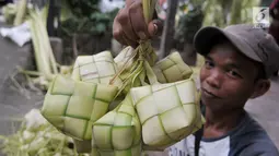 Pedagang menunjukan kulit ketupat yang akan dijual di kawasan Pasar Lenteng Agung, Jakarta, Kamis (22/6). Harga satu ikat kulit ketupat dijual pedagang dengan kisaran Rp10.000. (Liputan6.com/Yoppy Renato)