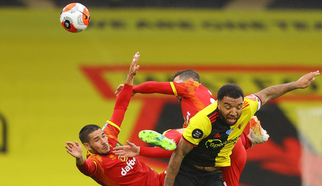 Striker Watford, Troy Deeney, berebut bola dengan pemain Norwich City pada laga lanjutan ke-34 di Stadion Vicarage Road, Rabu (8/7/2020) dini hari WIB. Watford menang 2-1 atas Norwich City. (AFP/Richard Heathcote/various sources)