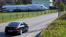 Sebuah mobil melintas dekat badan pesawat Fokker-100 yang terlihat diparkir di halaman rumah warga setempat di Strmec Stubicki, dekat Zagreb, Kroasia, 26 Oktober 2019. Butuh enam pekan untuk merobohkan pesawat dan lima hari untuk mengangkutnya. (Denis LOVROVIC / AFP)