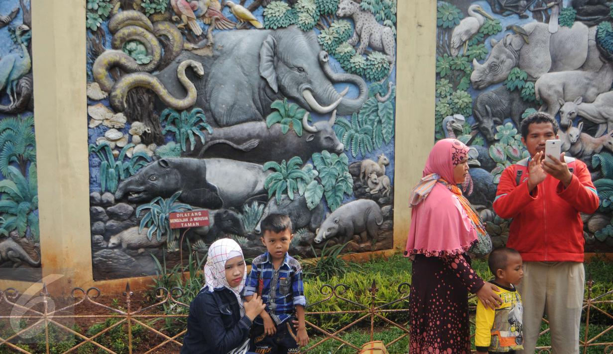 Salah satu tembok Ragunan yang berisi relief aneka binatang, Jakarta, Minggu (25/12). Harga tiket masuk yang murah menjadi salah satu alasan pengunjung memilih Ragunan sebagai tempat rekreasi bersama keluarga. (Liputan6.com/Helmi Afandi)