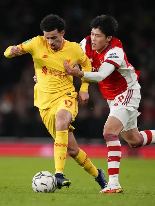 Bek Arsenal, Takehiro Tomiyasu berusaha merebut bola dari gelandang Liverpool Curtis Jones pada pertandingan leg kedua semifinal Piala Liga Inggris di Stadion Emirates di London, Jumat (21/1/2022). Dengan kemenangan ini Liverpool berhasil melaju ke final. (AP Photo/Matt Dunham)