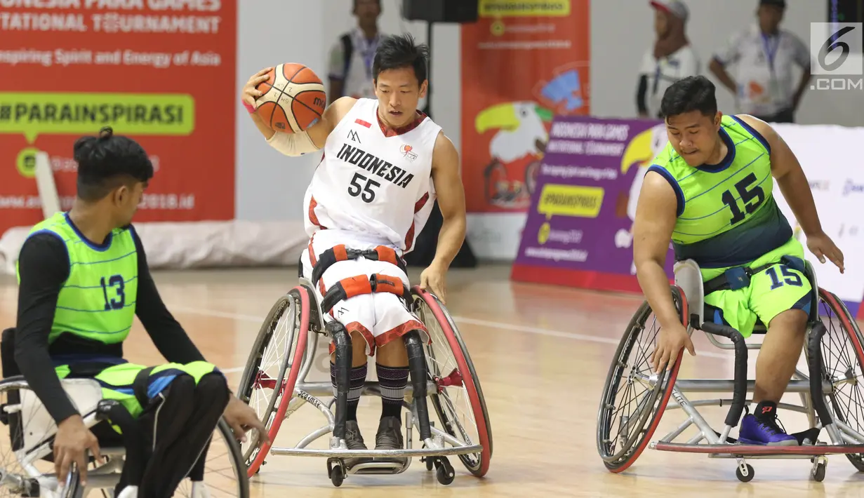 Pebasket difable Indonesia, Donald P Santoso (tengah) mencoba menembus kawalan pemain Malaysia pada laga Indonesia Para Games Invitational Tournament 2018 di Hall A Senayan, Jakarta, Minggu (1/7). Indonesia unggul 54-53. (Liputan6.com/Helmi Fithriansyah)