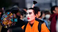 Orang-orang dengan kostum berjalan menyeberangi persimpangan jalan yang terkenal saat perayaan Halloween di distrik hiburan Shibuya, Tokyo, Jepang, 31 Oktober 2022. (AP Photo/Hiro Komae)