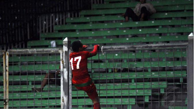 Ferdinand Sinaga memanjat pagar pembatas Stadion Utama Gelora Bung Karno, (11/5/2015). (Liputan6.com/Helmi Fithriansyah)