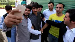 Senyum Arshad Khan setelah diwawancarai  sebuah televisi di Islamabad, Pakistan (20/10). Khan yang sebelumnya seorang penjual teh mendadak terkenal setelah fotonya menjadi viral media sosial. (Reuters/Faisal Mahmood)