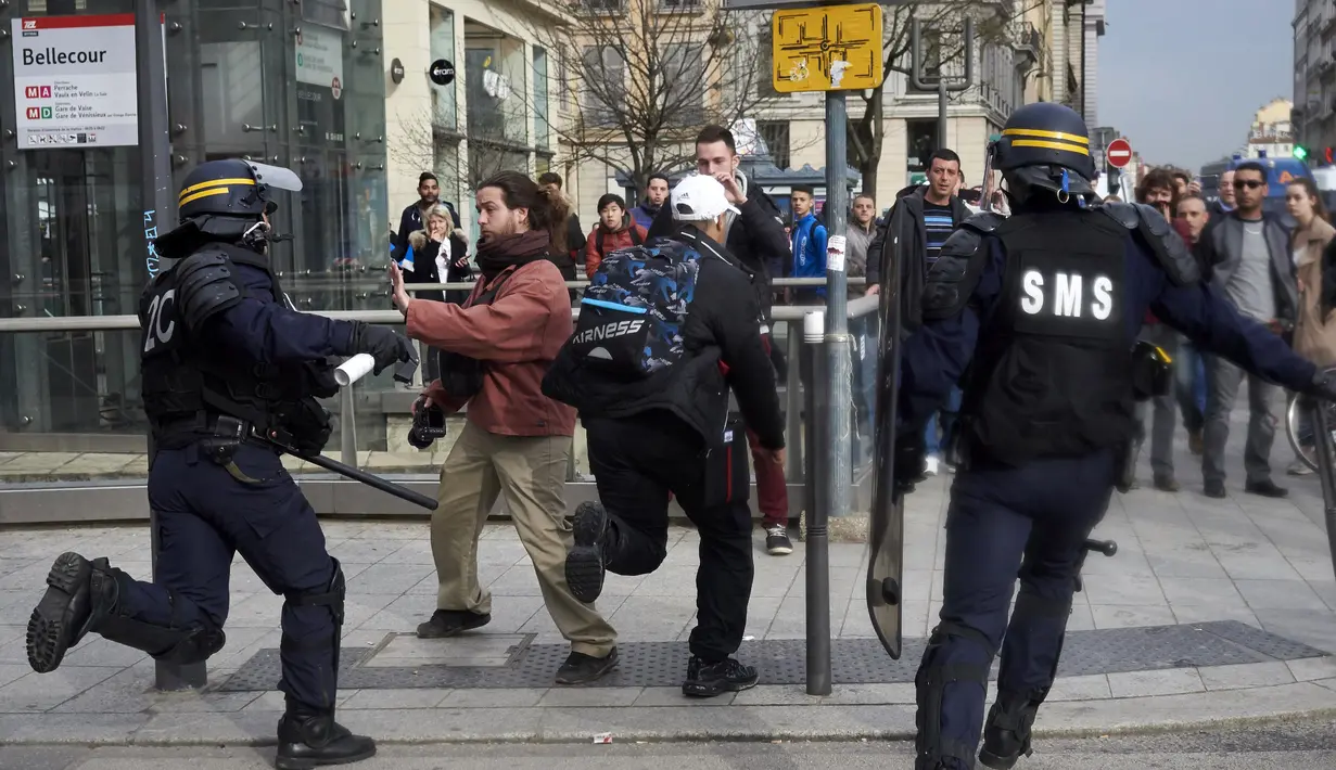 Pengunjuk rasa berhadapan dengan polisi anti huru hara saat unjuk rasa di Lyon, Perancis tengah timur, Kamis (31/3). Mereka menolak rancangan undang-undang sosialis pemerintah Prancis yang dinilai merugikan pekerja. (JEAN - PHILIPPE Ksiazek/AFP)