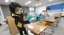 Petugas mendisinfeksi pembatas plastik pada meja untuk ujian masuk perguruan tinggi, Seoul, Korea Selatan, Selasa (1/12/2020). Sekitar 490.000 siswa lulusan sekolah menengah atas di Korea Selatan akan menjalani Tes Kemampuan Skolastik Perguruan Tinggi pada 3 Desember 2020. (AP Photo/Ahn Young-joon)