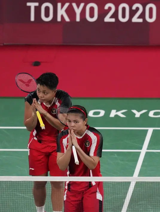 Ganda putri Indonesia Greysia Polii (depan) dan Apriyani Rahayu setelah memenangkan pertandingan Grup A bulu tangkis Olimpiade Tokyo 2020 melawan Chow Mei Kuan dan Lee Meng Yean dari Malaysia di Musashino Forest Sport Plaza, Sabtu (24/7/2021). Greysia / Apriyani menang 21-17. (AP/Markus Schreiber)