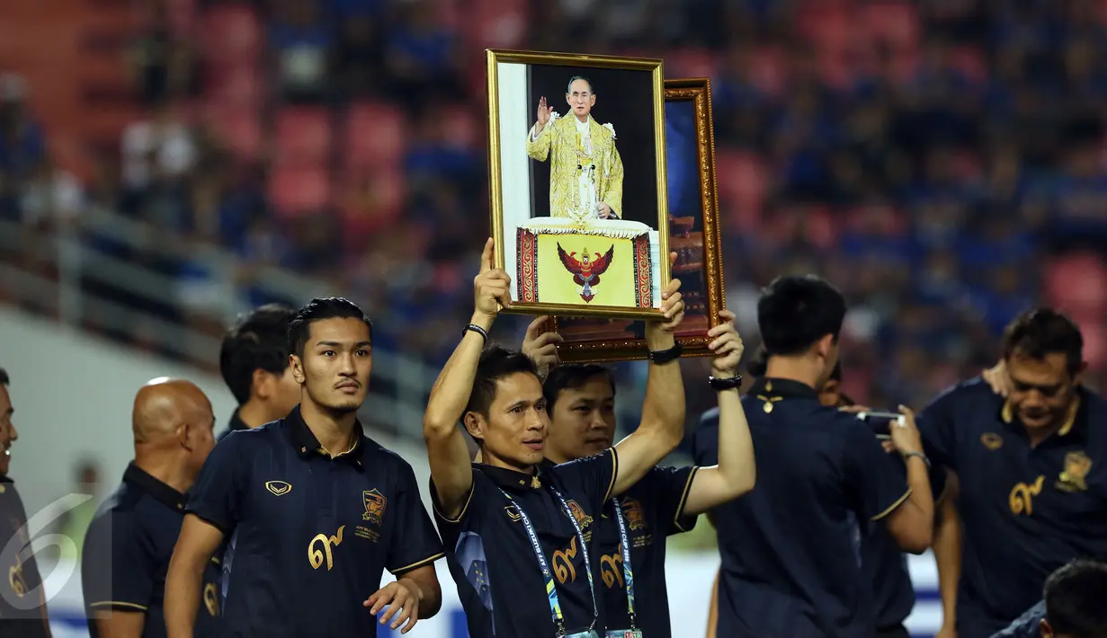 Pemain Timnas Thailand mengangkat foto Sang Raja saat menyambut kemenangan atas Indonesia di National Stadium Rajamangala, Bangkok, Sabtu (17/12). Thailand berhasil meraih piala AFF untuk yang kelima kali. (Liputan6.com/Helmi Fithriansyah)