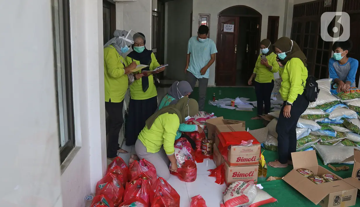 Warga sedang mengemas makanan di Jalan As-Syafiiyah, Cipayung, Jakarta Timur, Jumat (21/5/2021). Sebanyak 51 orang warga di RT03/RW03 Kelurahan Cilangkap Kecamatan Cipayung positif Covid-19 yang berasal dari klaster halal bi halal saat lebaran Idul Fitri. (Liputan6.com/Herman Zakharia)
