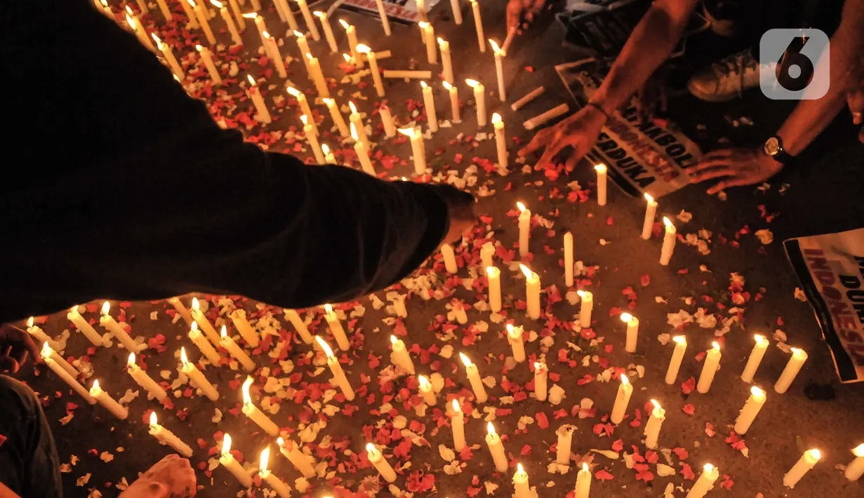 Massa yang tergabung dalam Ultras Garuda Jakarta menggelar aksi seribu lilin dan tabur bunga untuk korban kerusuhan Stadion Kanjuruhan Malang di depan Stadion Gelora Bung Karno (GBK), Jakarta, Minggu (2/10/2022). Aksi yang diikuti ratusan pecinta sepakbola di Jakarta tersebut sebagai bentuk belasungkawa terhadap ratusan korban yang tewas dalam kerusuhan di Stadion Kanjuruhan Malang kemarin. (merdeka.com/Iqbal S Nugroho)