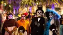 Peserta mengenakan kostum mirip figur terkenal Catrina selama Prosesi Grand Catrinas, bagian dari perayaan Day of The Dead, di Mexico City, Minggu (22/10). Banyak orang yang mengenakan kostum dan hiasan tengkorak memenuhi jalanan. (AP/Rebecca Blackwell)