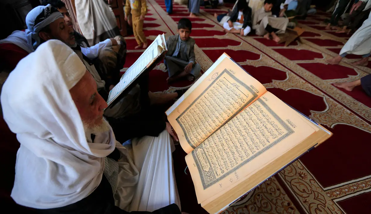 Para jemaah Masjid Agung Sanaa, Yaman bertadarus menggunakan Alquran berukuran besar. (MOHAMMED HUWAIS/AFP)