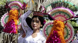 Seorang wanita membawa persembahan saat pembukaan Pesta Kesenian Bali di Bali, Indonesia, 12 Juni 2022. Pulau Bali saat ini menggelar Pesta Kesenian Bali tahunan selama sebulan dari 12 Juni hingga 10 Juli. (AP Photo/Firdia Lisnawati)