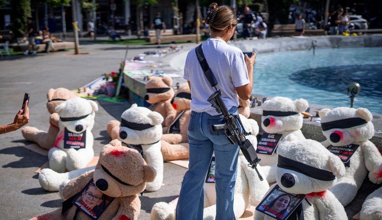 Para tentara yang sedang tidak bertugas tetap harus membawa senjata mereka ketika ke pantai, mal, taman, atau ke mana pun mereka ingin pergi. (AP Photo/Oded Balilty)