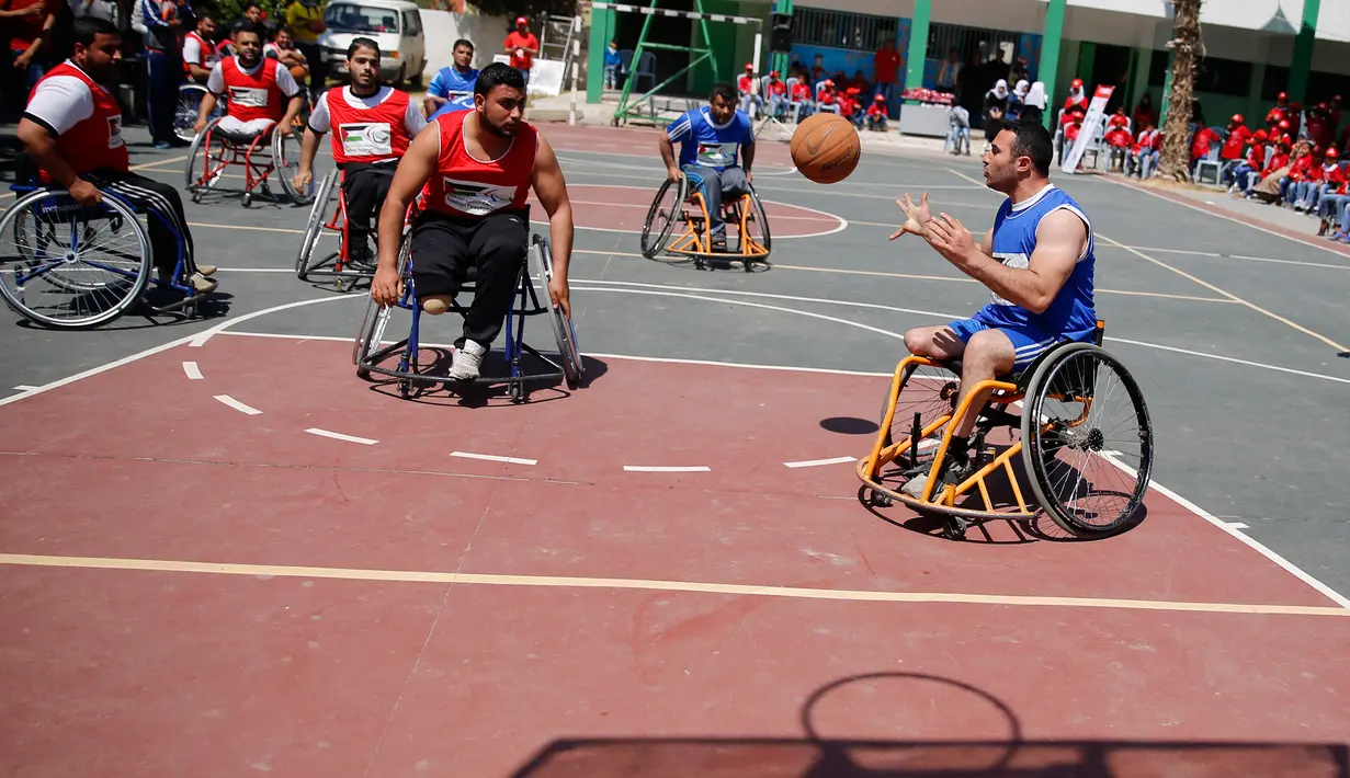 Sejumlah pria yang menggunakan kursi roda bermain basket di lapangan sekolah milik pemerintah di Kota Gaza (4/4). Meski telah kehilangan anggota tubuhnya, mereka tetap semangat menjalani hidup. (AP Photo/Hatem Moussa)